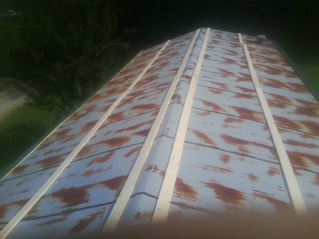 Rusted metal roof panels with new wood purlins before replacement — Storm Damage Roof Repair in Alma by Roofing Brothers