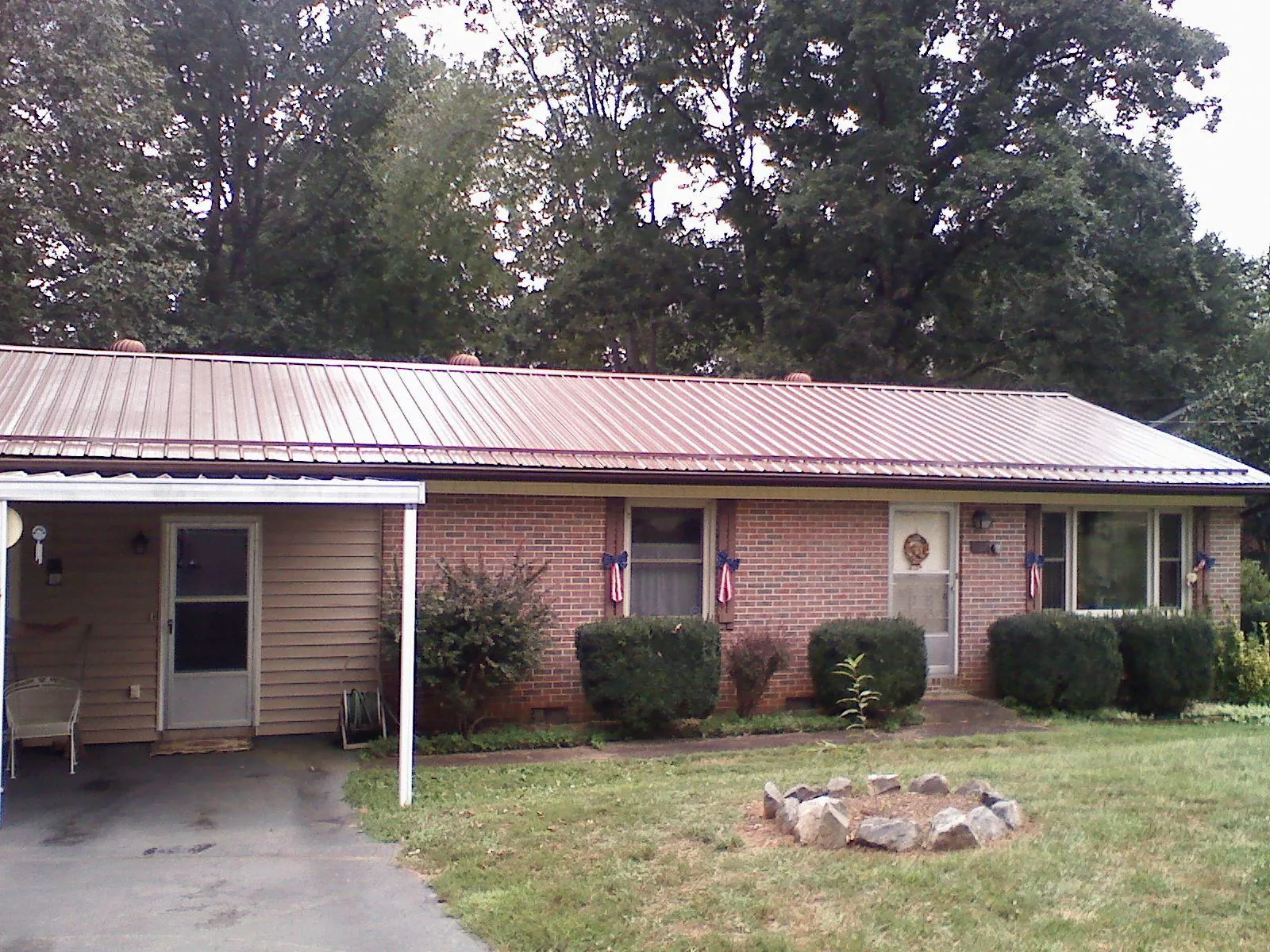 Bronze metal roof and carport on a brick ranch home — Roof Repair work by our crew in Alma